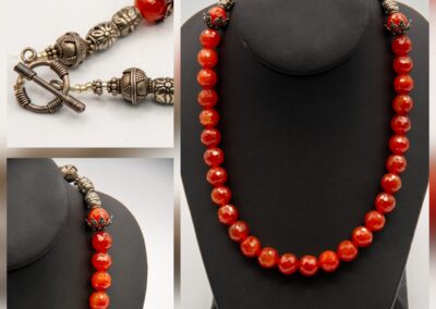 Elegant necklace with red beads and vintage-style clasp.