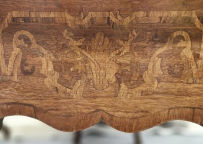 Intricately carved wooden panel with symmetrical mythical creatures and floral motifs.