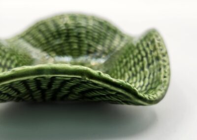 Close-up of a green ceramic dish with textured patterns.