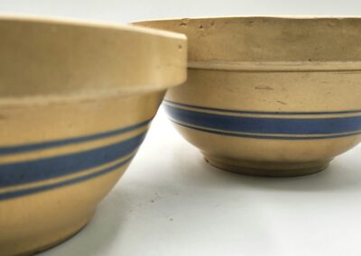 Two ceramic bowls with blue stripe patterns on a white background.