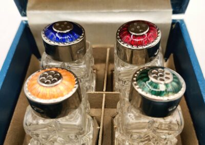 Set of four vintage glass condiment jars with colorful lids in a blue box.