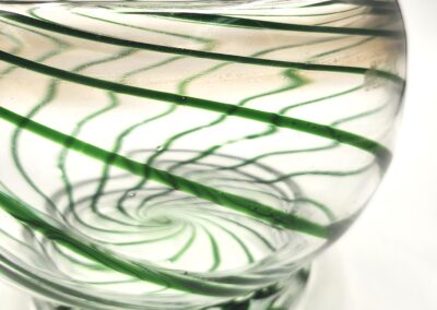Close-up of a glass bowl with green spiral patterns.