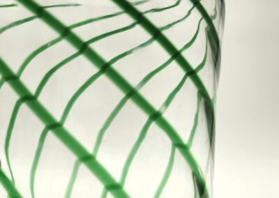 Close-up of a clear glass with green leaf patterns.