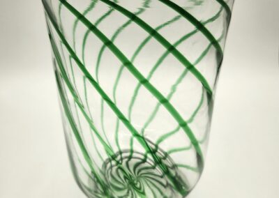 A glass tumbler with green spiral stripes on a white background.