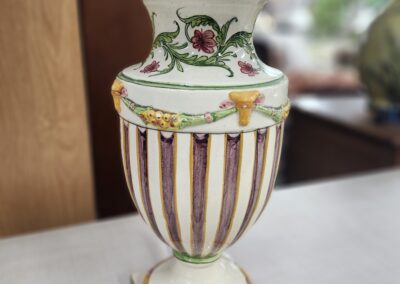 Decorative vintage porcelain urn with floral design and gold accents.