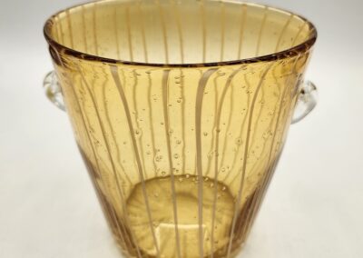 Transparent amber glass bucket with vertical ridges and side handles.