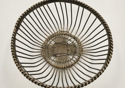 Top view of a round woven basket with intricate spiral design.