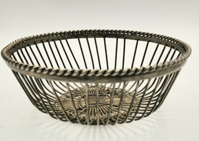 Intricately designed metal wire basket with a circular open structure.
