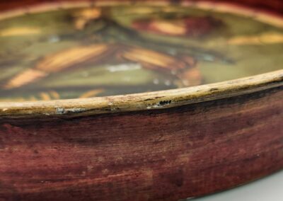 Close-up of a wooden bowl with a glass cover and a leather strap.