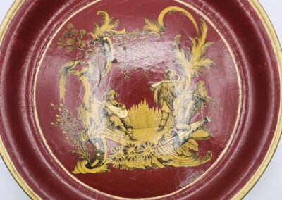 Decorative red plate with intricate gold and white designs.