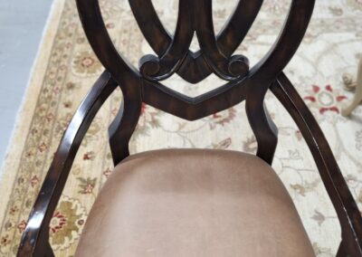 Elegant wooden chair with a cushioned seat and intricate backrest design.