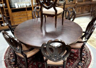 Elegant wooden dining table with matching chairs on a decorative rug.