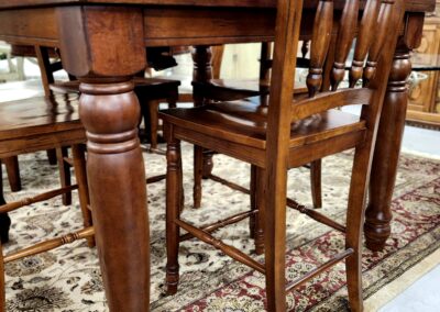 Classic wooden dining table with matching chairs on a patterned rug.