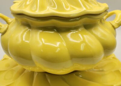 Bright yellow ceramic pumpkin-shaped container with a lid.