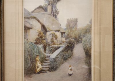 A rustic stone cottage with a garden and a cat in front of it.
