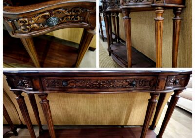 Ornate wooden console table with carved details and curved legs.