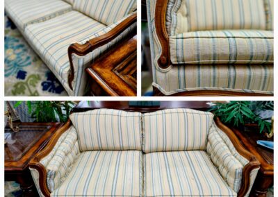 Elegant antique wooden sofa with striped beige cushions.