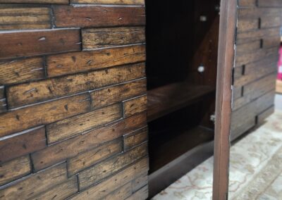 Wooden cabinet door slightly ajar showing dark interior.