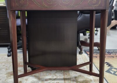 Antique wooden side table with elegant carvings and tapered legs.