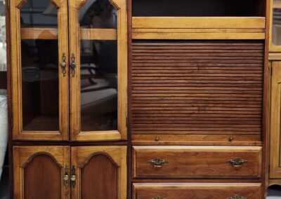 Wooden cabinet with glass doors, drawers, and a roll-top section.