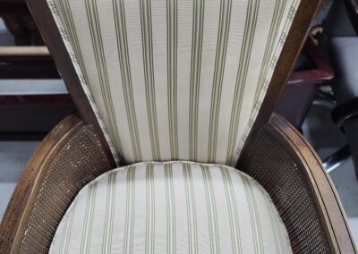 Wooden chair with beige and green striped upholstery.