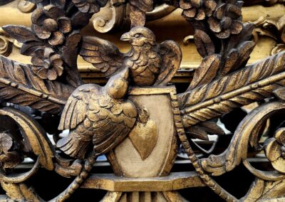 Intricate wooden carving with a bird and shield motif.