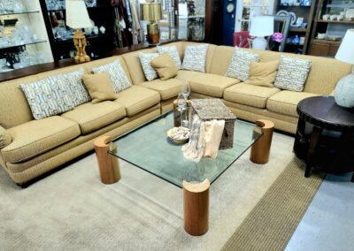 Elegant beige sectional sofa with a glass coffee table in a cozy living room.