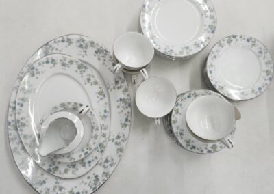 Elegant white porcelain dinnerware with silver floral patterns.