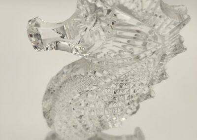 Intricately carved clear crystal seahorse sculpture with detailed features.