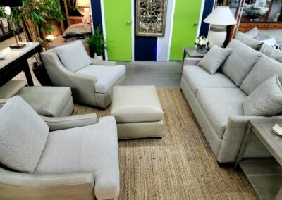 Modern beige living room set with green wall accents and natural light.