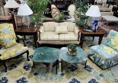 Vintage living room with floral sofa and patterned carpet.