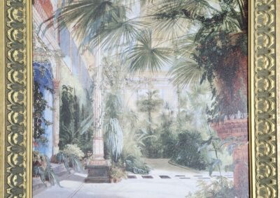 A framed painting of a sunlit garden with palm trees and a pathway.