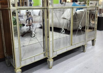 Elegant mirrored console table with decorative legs and reflective panels.