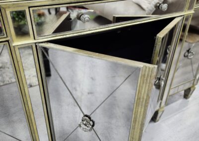 Elegant mirrored cabinet with geometric designs and reflective surfaces.