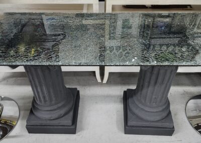 Glass table with carved column-style black bases.