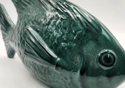 A green ceramic fish figurine with detailed scales and fins.