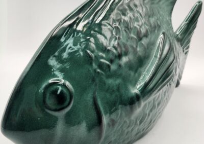A glossy green ceramic fish sculpture with detailed features.