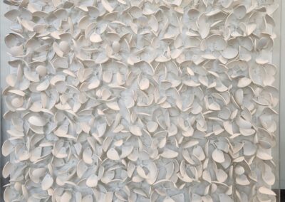 Abstract wall art with layered white petals creating texture.