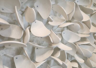 Close-up of white ceramic pieces with holes, arranged artistically.