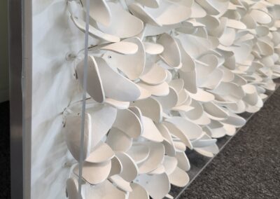 Close-up of white paper art installation with layered, curved shapes.