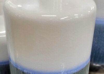 A white and blue ceramic bottle with a textured surface.