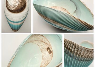 Elegant ceramic bowl with aqua and brown glaze and textured ridges.