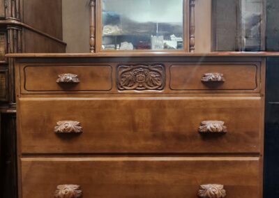 Vintage wooden dresser with four drawers and carved details.
