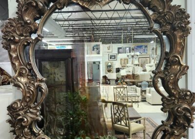 Ornate vintage mirror reflecting a cozy interior space.