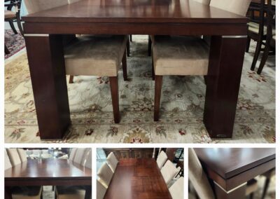 Elegant dark wood dining table with six beige upholstered chairs on a patterned rug.