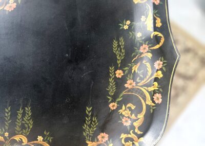 Ornate black tray with intricate gold and floral designs on scalloped edges.