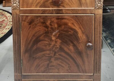 Vintage wooden cabinet with intricate grain patterns and three drawers.