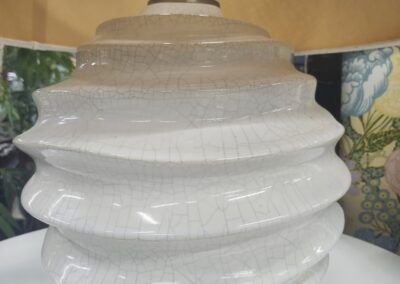 Close-up of a white, layered ceramic vase with a textured surface.