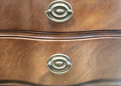 Close-up of wooden drawer handles with a vintage design.