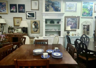 A cozy dining room with wooden furniture and framed artwork on the walls.